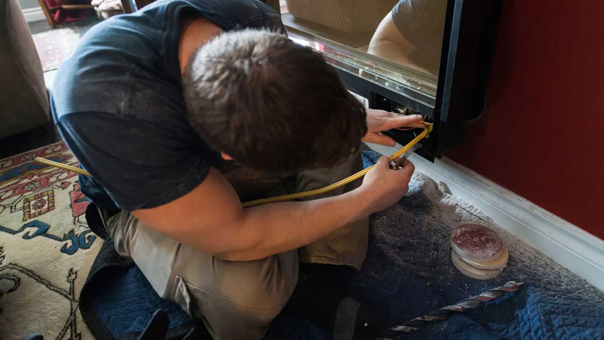 Repair man working on fireplace