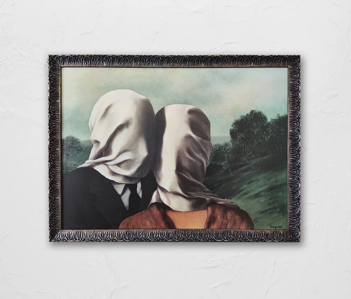 A framed painting of two people kissing, both with their heads wrapped in white cloth, set against a backdrop of a green landscape with trees and a cloudy sky.