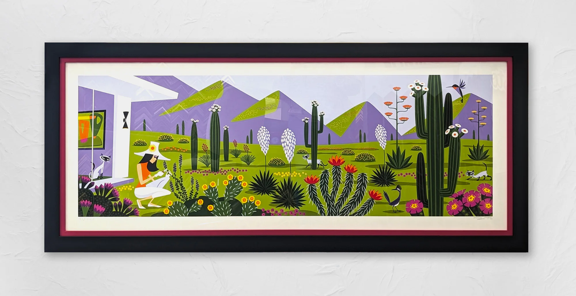 Framed illustration of a desert scene with cacti, various colorful plants, a woman in a sunhat gardening, animals such as cats and birds, and purple mountains in the background.