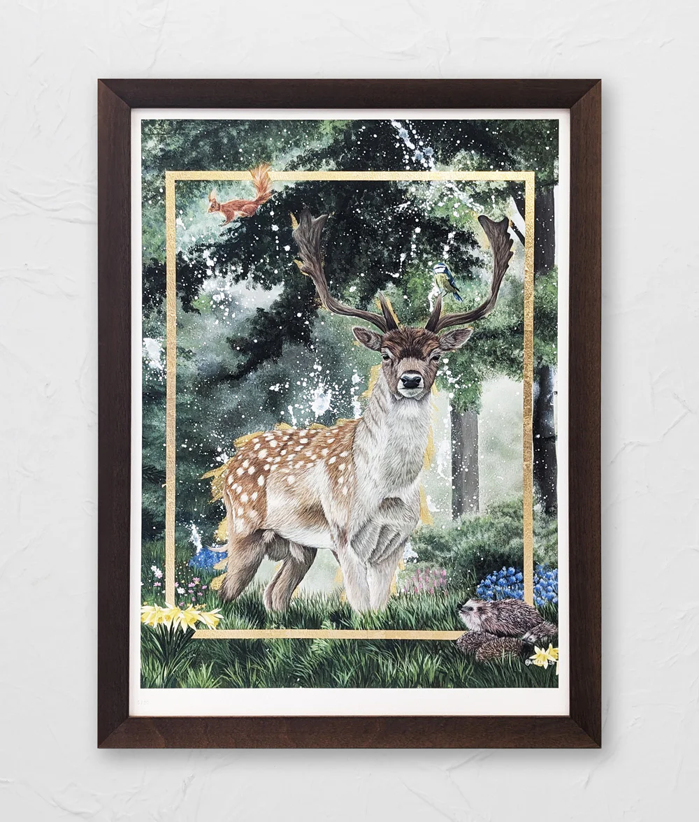 Framed painting of a deer with antlers in a forest, featuring a bird perched on its antlers, a squirrel on a tree branch above, and a hedgehog among flowers and grass below.