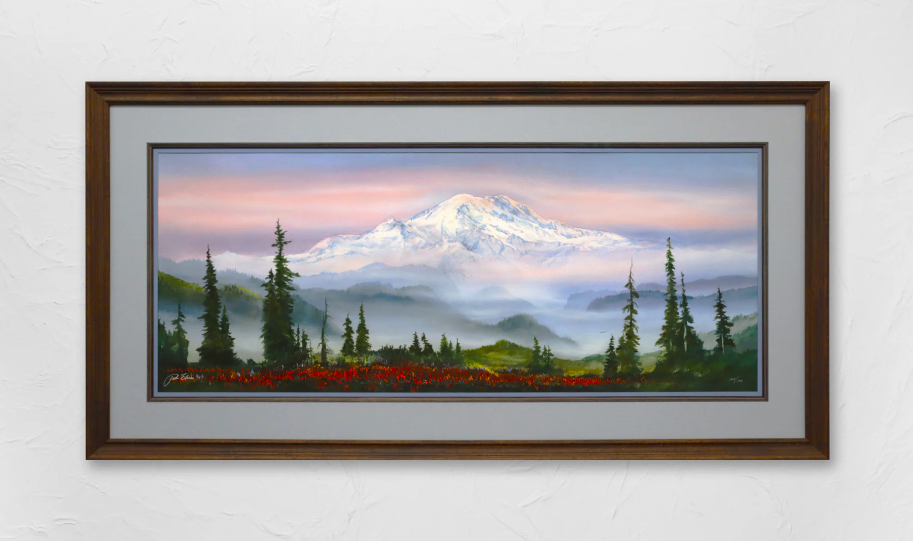 Framed painting of a snow-capped mountain at sunset with pine trees in the foreground and a red flower field at the bottom. The sky is filled with soft pastel colors.