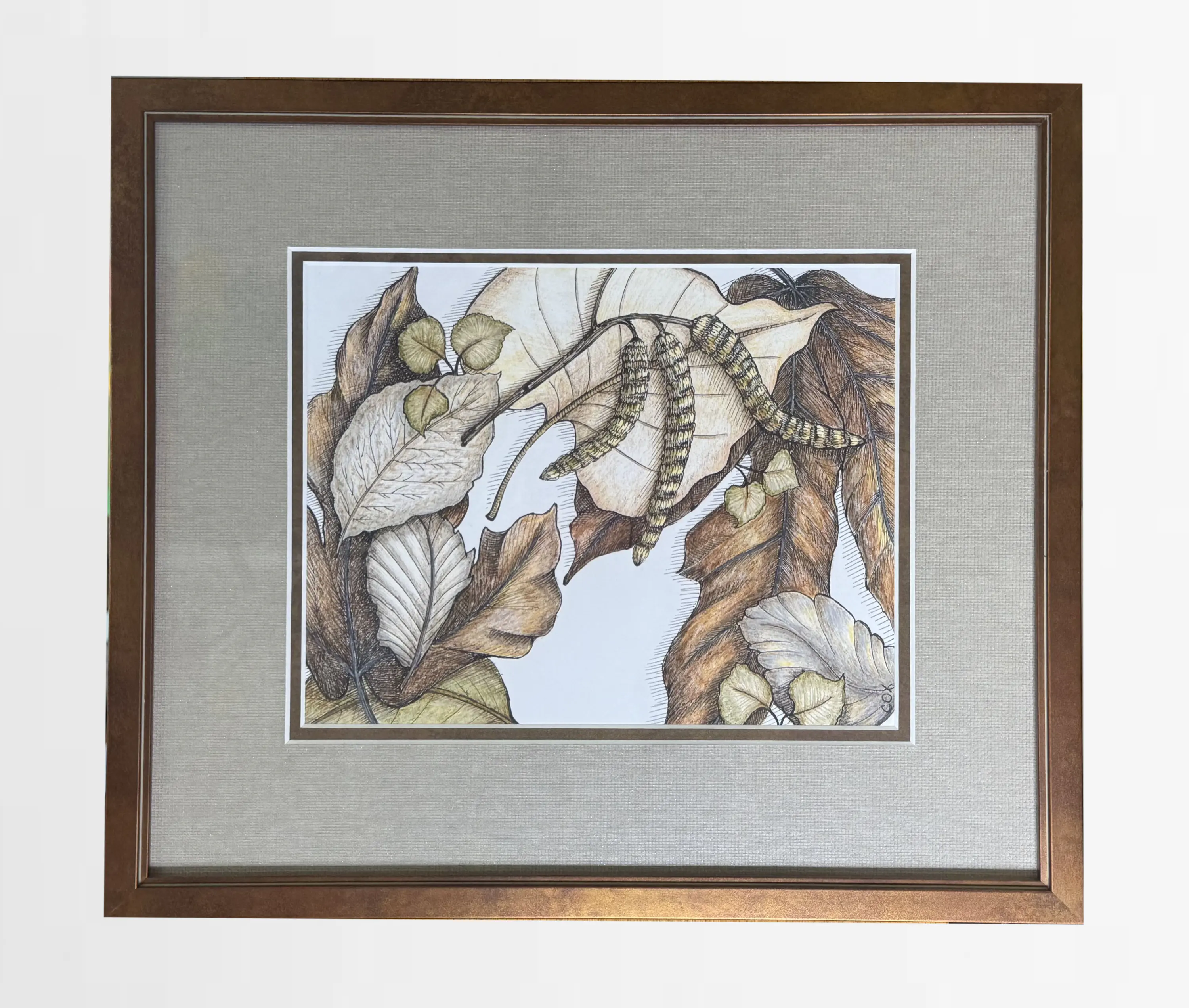 Framed artwork depicting two caterpillars on a collection of autumn leaves in shades of brown, beige, and green, set against a white background with a bronze frame.