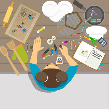 Person crafting at a table with various supplies like glue, markers, scissors, and a notebook. Other items include a rolling pin, oven mitt, and kitchen utensils.