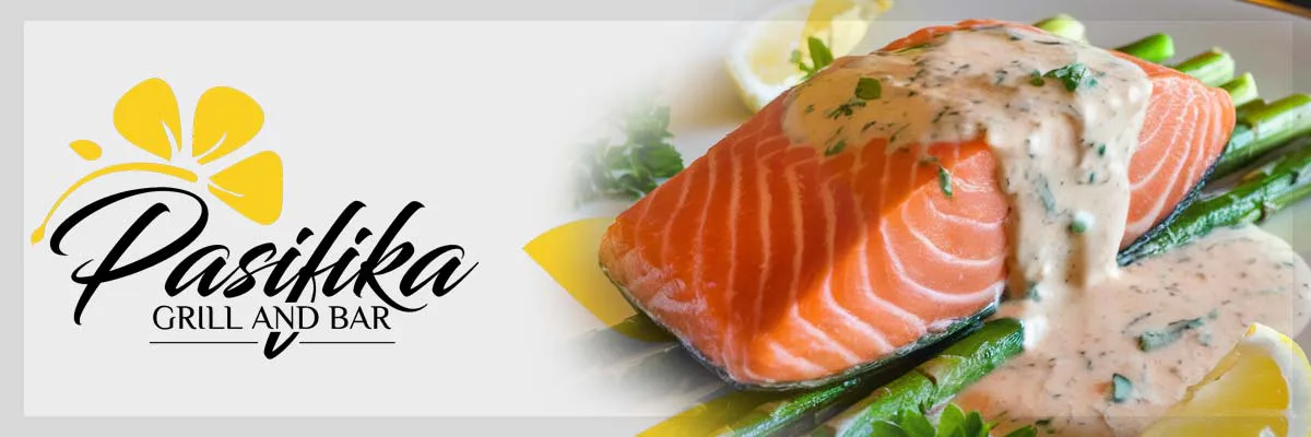 Grilled salmon fillet with creamy sauce on asparagus, garnished with lemon slices. Pasifika Grill and Bar logo with yellow flower in the background.